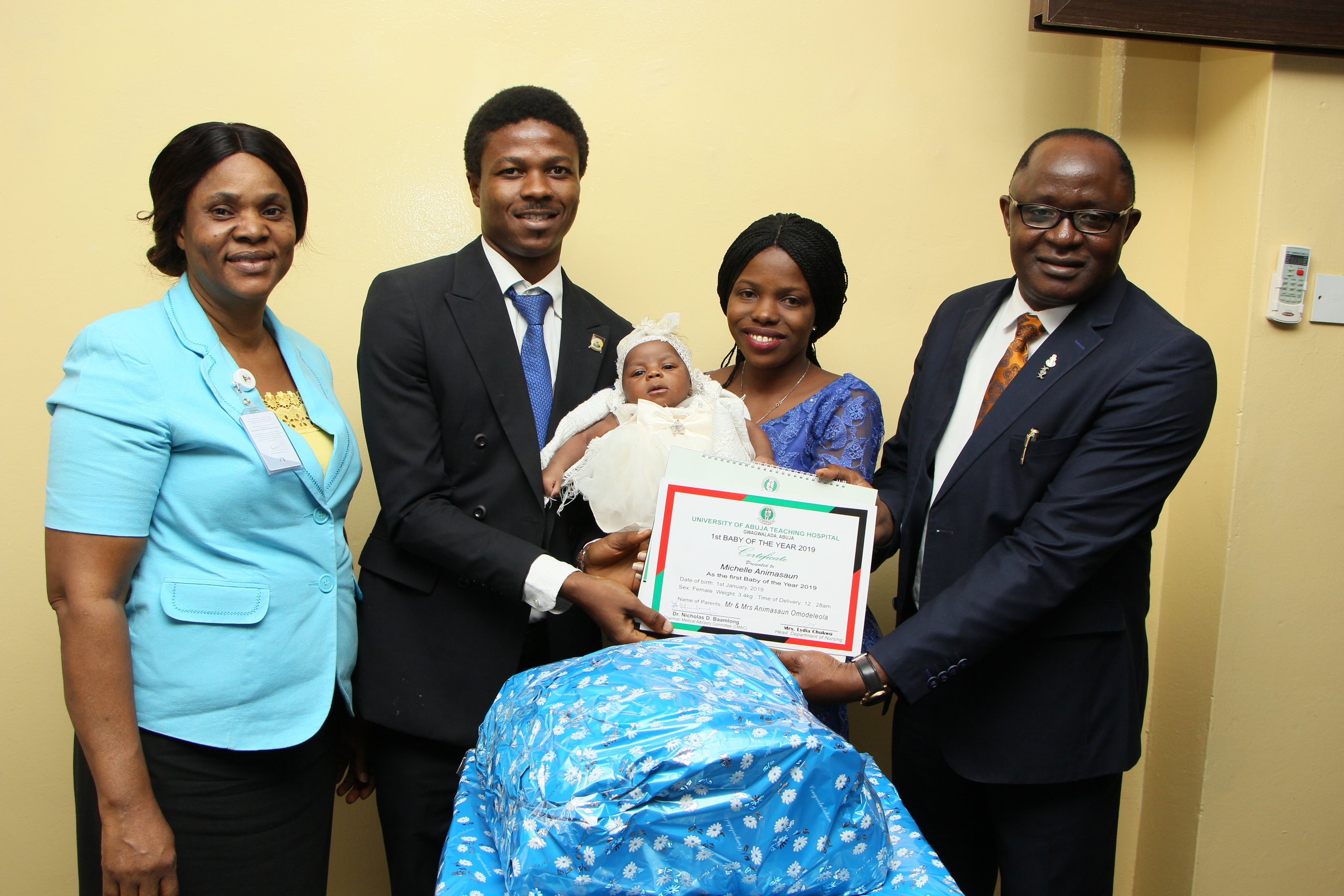 (R) The Chairman, Medical Advisory Committee, University of Abuja Teaching Hospital, Dr. Nicholas Baamlong presenting gifts to the baby with her parents. On the left is the Head, Department of Nursing, University of Abuja Teaching Hospital, Mrs. Lydia Chukwu.